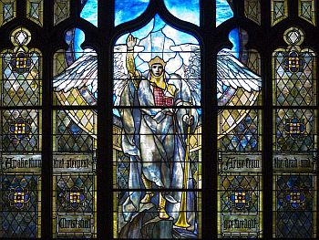 stained glass window of angel with hand raised